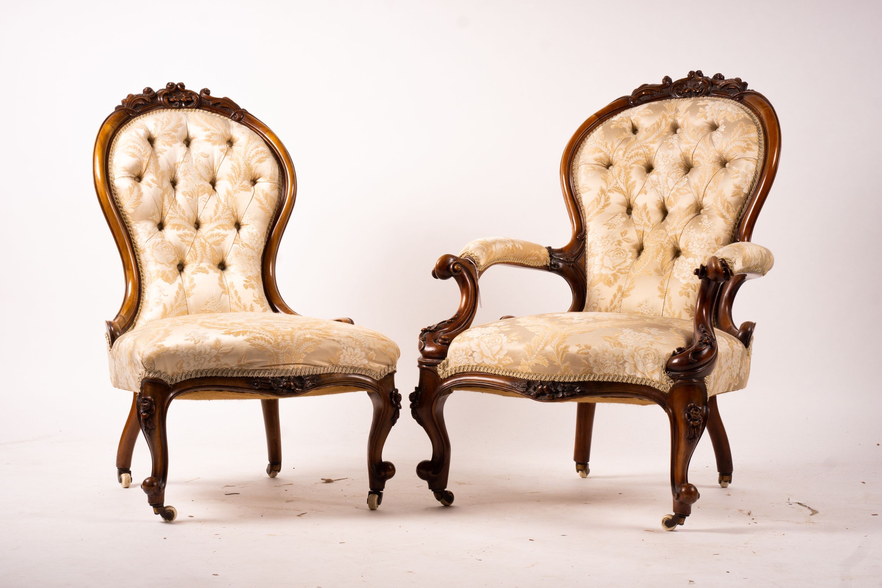 A late Victorian carved walnut three piece salon suite, comprising chaise longue, open armchair and nursing chair